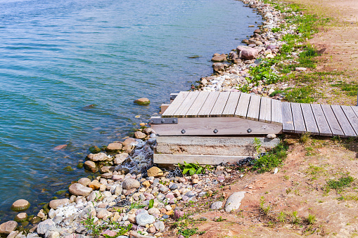 pier on the shore of the lake with a lot of stones