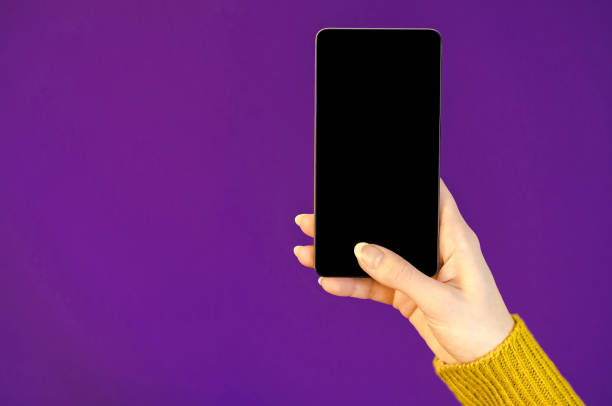 istock Woman hands yellow sweater using cellphone holding smart mobile phone with oled display ultra violet color year background. Close up Flat Lay bussines composition Top view trend 910169450