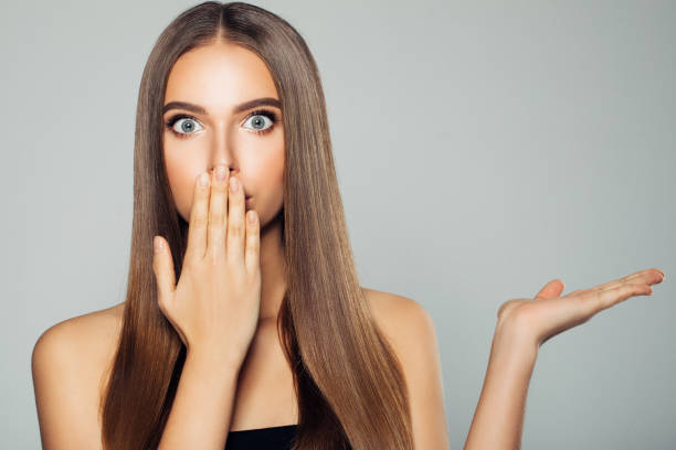 istock Smiling woman holding something on hand and demonstrating it 910177340