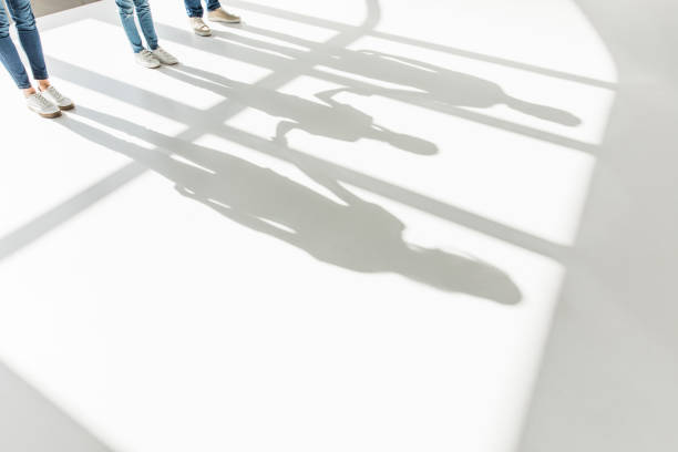 copped shot of family standing together and shadows on white