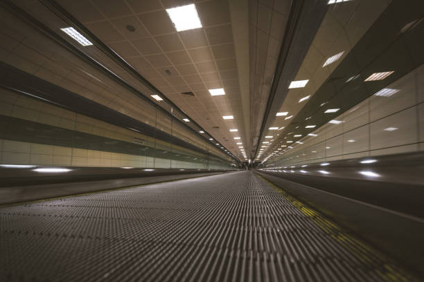 istock Traveller walking on moving stairway airport walkway 910189428