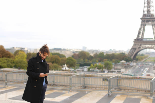 istock Arabian groom talking on smartphone near Eifel Tower in slow mot 910191990