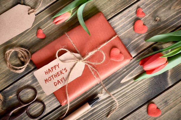 istock Packed gift box, cord, scissors, tags and decorative hearts on wood 910195684