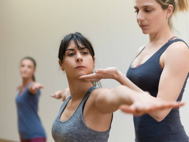 istock Yoga instructor and woman stretching arms 910196408