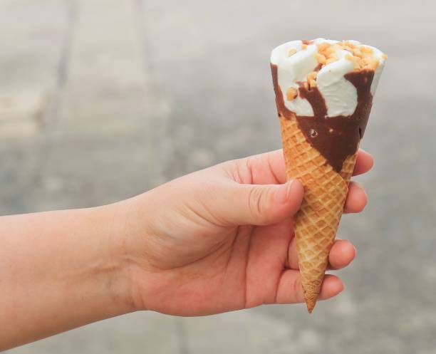 istock Hand Holding Ice Cream Cones with Chocolate 910200826