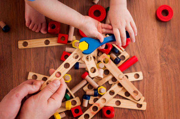 istock Father with son plays in a wooden constructor with a spanner and bolts 910214082