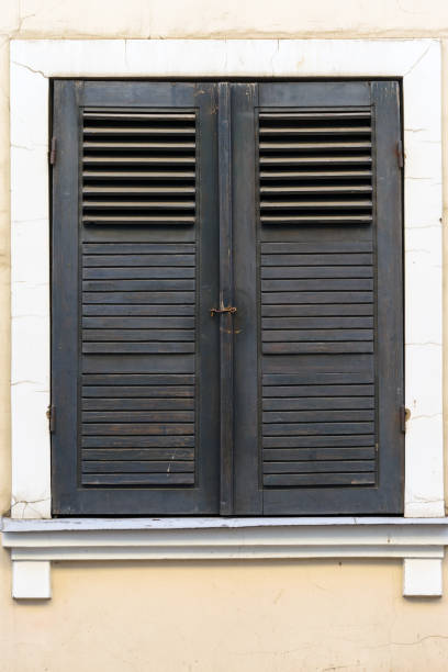 istock old windows with brown wooden shutter, classic facade 910214332