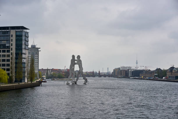 Berlin, Germany - April 5, 2017: Statue of Molecule Man at the Spree river on a cloudy day in Berlin