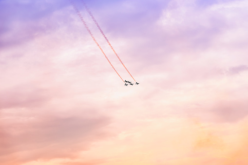Group of aircraft flying at sunset. Exciting performance. Air performance, air show, aircrafts, flying display and skill teamwork. Abstract background, copy space