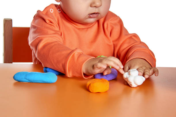 istock Child hands playing with colorful clay. Isolated on white background 910221950