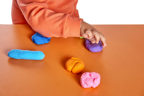 istock Child hands playing with colorful clay. Isolated on white background 910222062