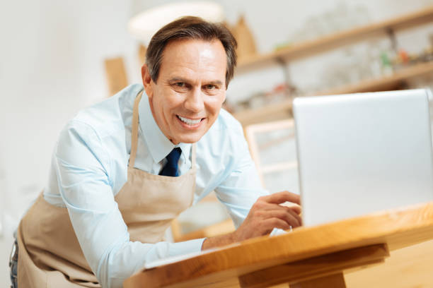 istock Gay satisfied man smiling and using the laptop 910225324