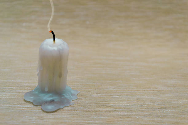 Candle burn and smoke, warm light on the wall background.
