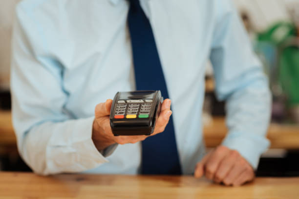 istock Busy smart man standing and showing the cash machine 910225680