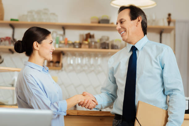 istock Confident smiling colleagues standing and shaking hands 910225950
