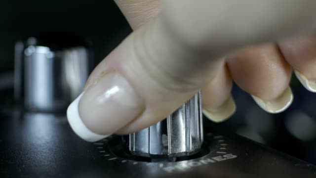 Female fingers turning silver audio interface knob