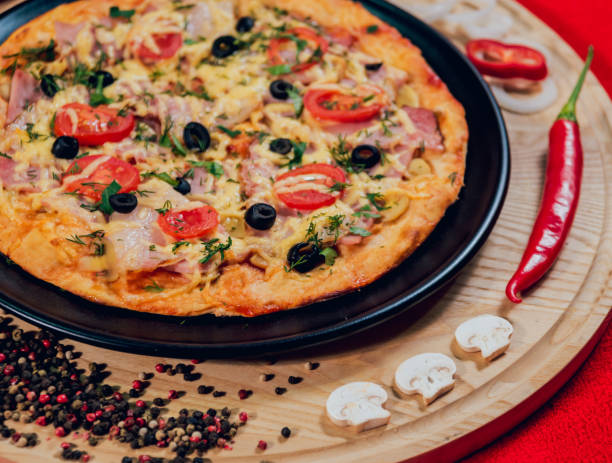 istock Large hot pizza on the black plate. 910228004