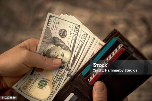 High Angle View Of Unrecognizable Mature Man Placing Usa Dollar Bills Into Wallet Stock Photo - Download Image Now