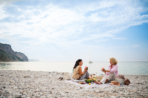Senior women have picnic on beach
