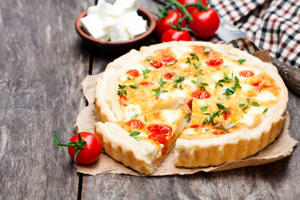 istock Cherry  tomatoes and cheese tart on wooden background 910231732