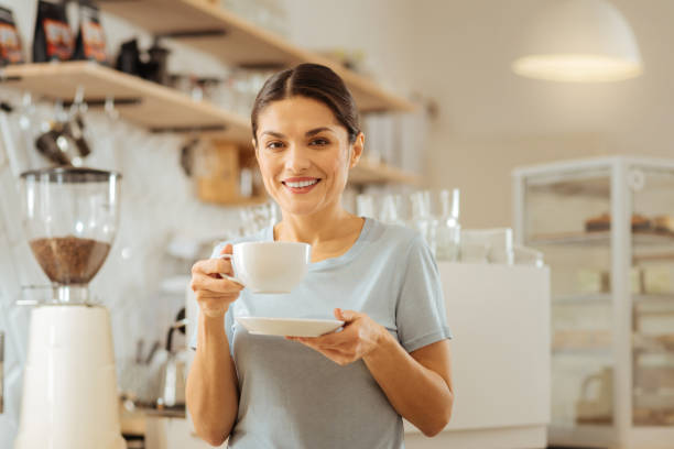 istock Pretty joyful woman standing and drinking coffee 910231766