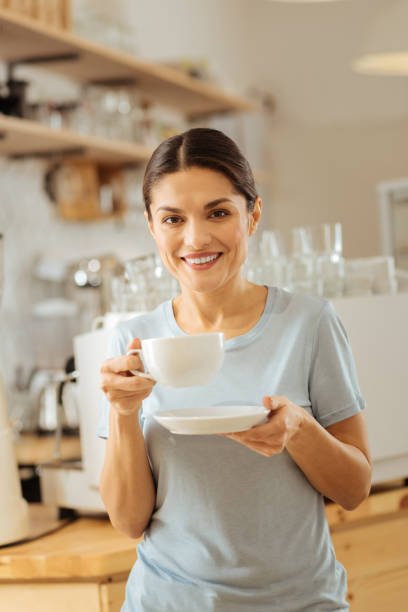 istock Cute pleasant lady holding a cup and smiling 910231772