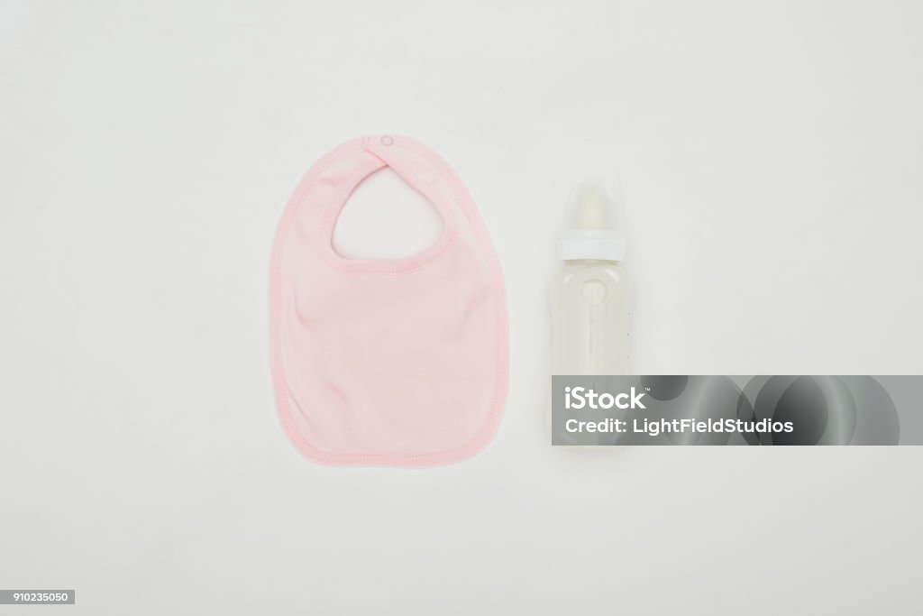 top view of baby bib and bottle of milk isolated on white Baby Bib Stock Photo