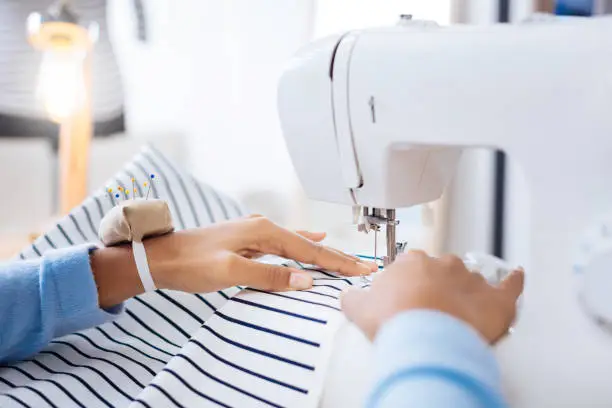 Photo of Calm worker of a professional atelier working on a sewing machine