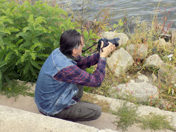 istock A man photographs from the water edge 910237878