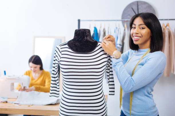 istock Pretty woman smiling while standing with her hands touching the mannequin 910238140