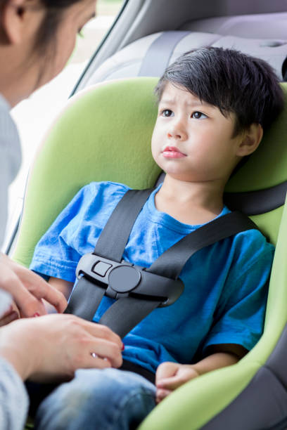 istock Mom strap adorable son into car seat 910238372