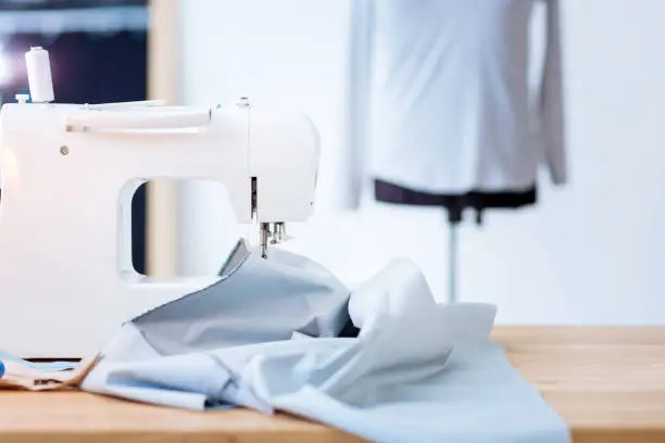 Photo of Big piece of fabric resting on the table near a sewing machine