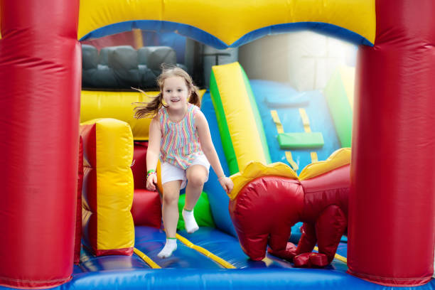 istock Child jumping on playground trampoline. Kids jump. 910238810