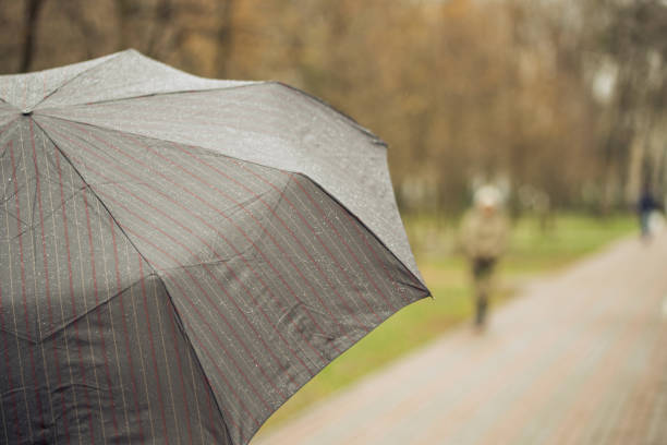 istock Close-up of dark umbrella during rain. 910241642