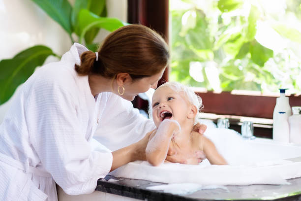 istock Mother washing baby in bubble bath. Water fun. 910245280