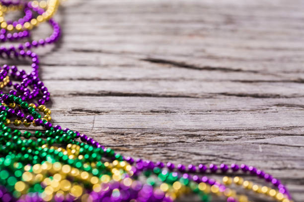 Mardi gras beads on a rustic wood background with copy space.