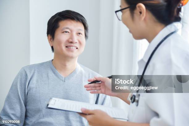 Female Doctor Examining Male Patients Stock Photo - Download Image Now - Patient, Doctor, Medical Exam