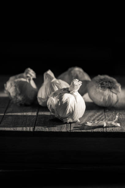 istock Garlic bulbs on a cutting board, moody lighting 910296478