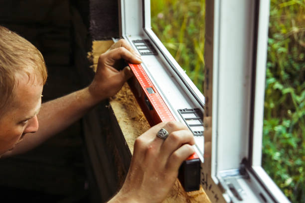worker checks the level of a window stock photo