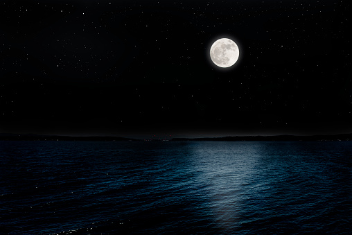 Full moon rising over the peninsula with lots of shining stars from shining night sea.