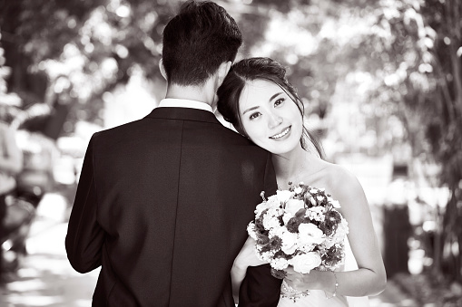 portrait of young asian bride and groom at wedding ceremony, black and white.