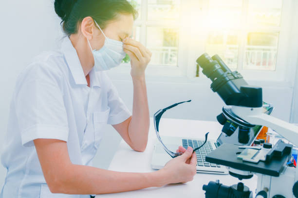istock Tired overworked scientist woman at lap covering her face with hands,science content,science concept and selective focus. 910318134