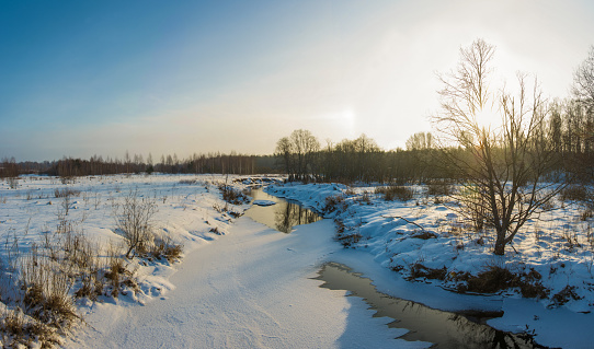 Beautiful landscape with a small river in a winter sunny day.