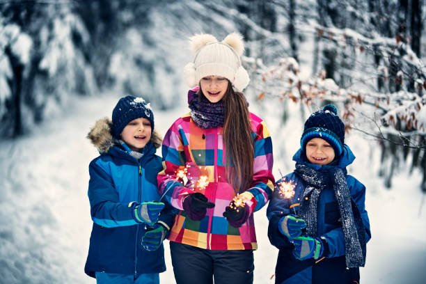 istock Children with sparklers in winter forest 910336286