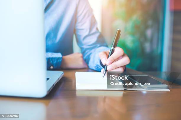 Business Woman Hand Is Writing On Notepad With Pen In Office Stock Photo - Download Image Now