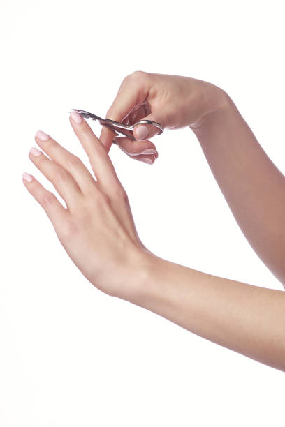 woman cuts nails scissors, close up. on a white background
