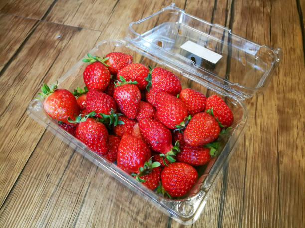 istock Strawberry packaging opened on wooden background. 910340268