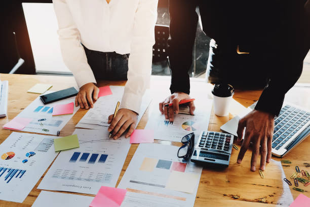 istock business meeting concept, calculate financial & budget & stock market data document with notebook and laptop computer in working on wood desk in office. 910343622