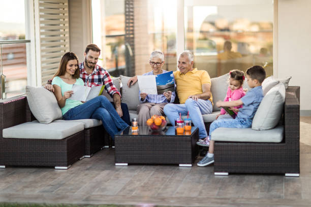 Happy extended family relaxing on sofa at penthouse patio.