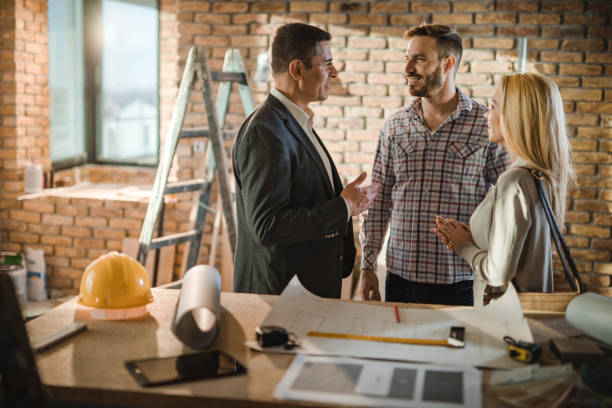 istock Smiling architect talking to couple during home improvement process. 910348568